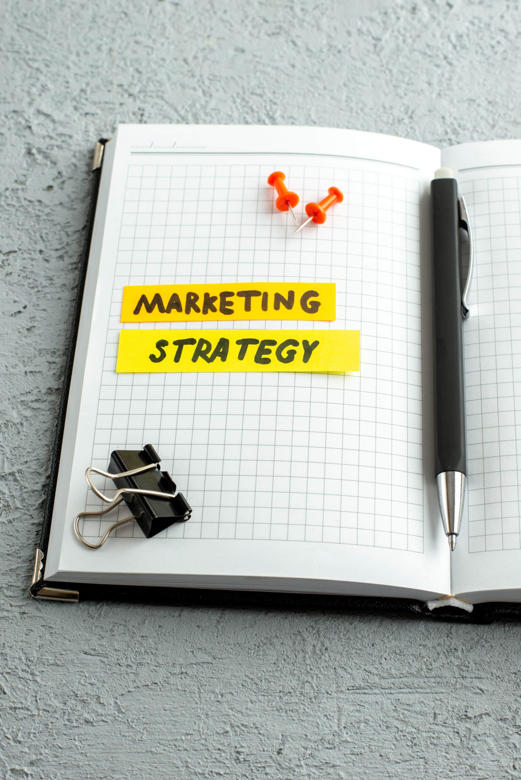marketing strategy post it notes on a notebook with pen