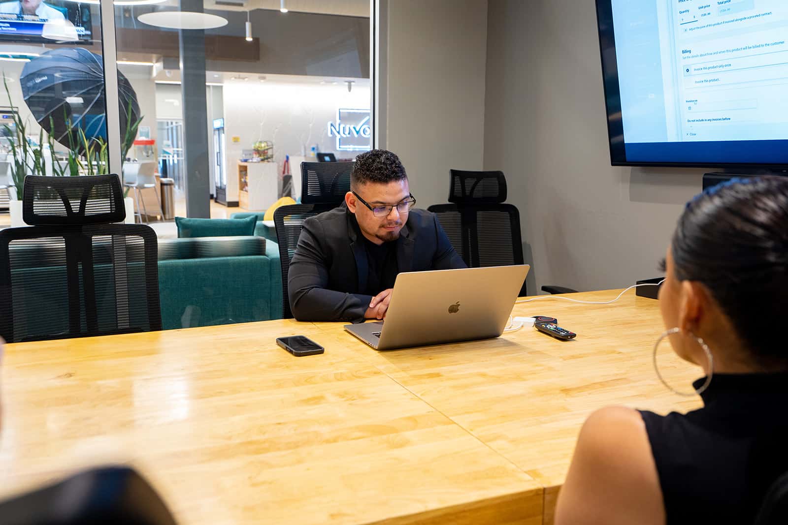 bryan sitting in a conference room at nuvo desk in a meeting