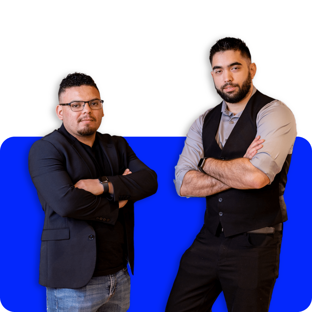 Two confident men standing with arms crossed in front of a vibrant blue background, portraying professionalism and leadership.