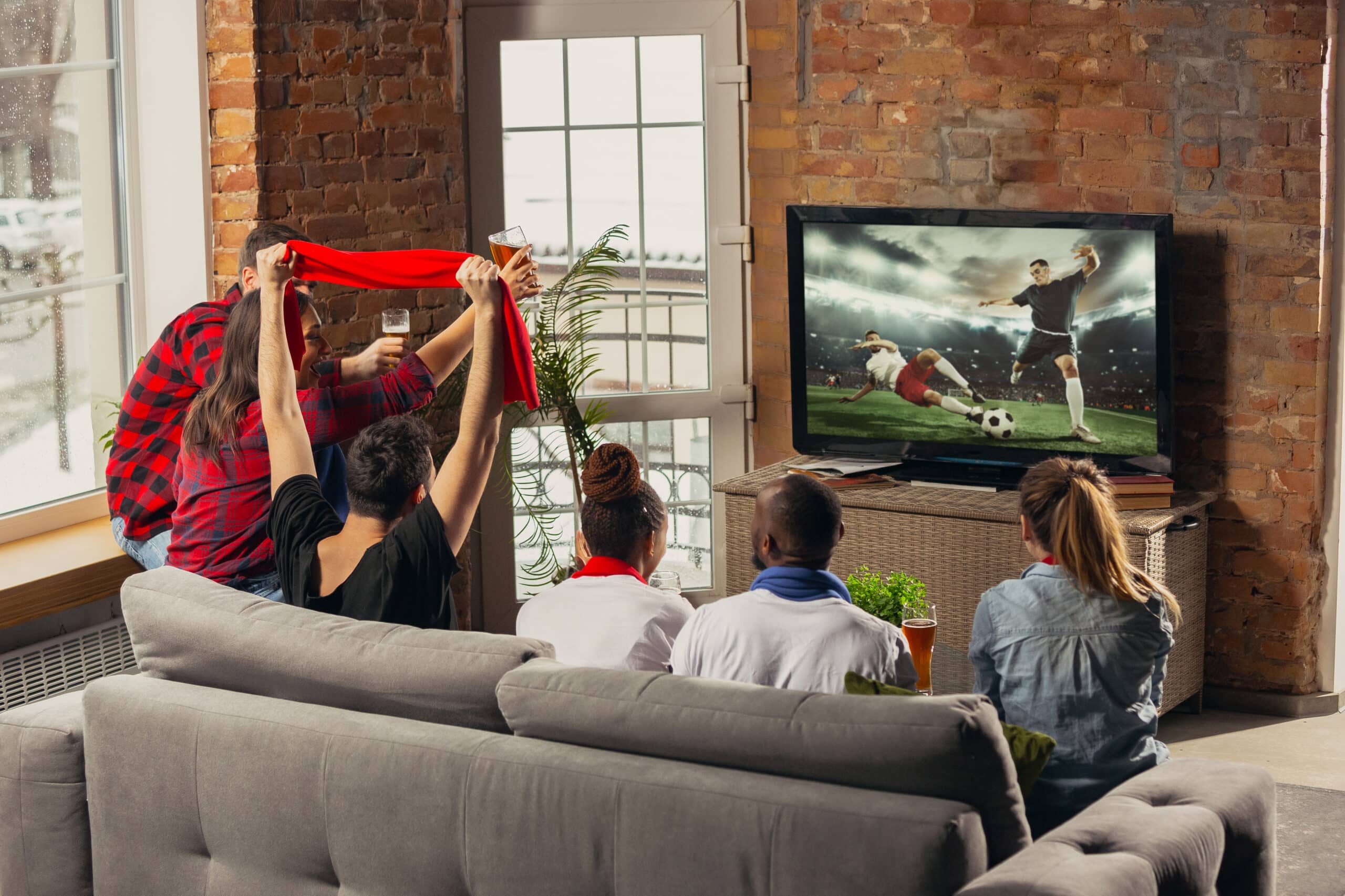 Group of friends watching soccer game on TV with streaming advertising services