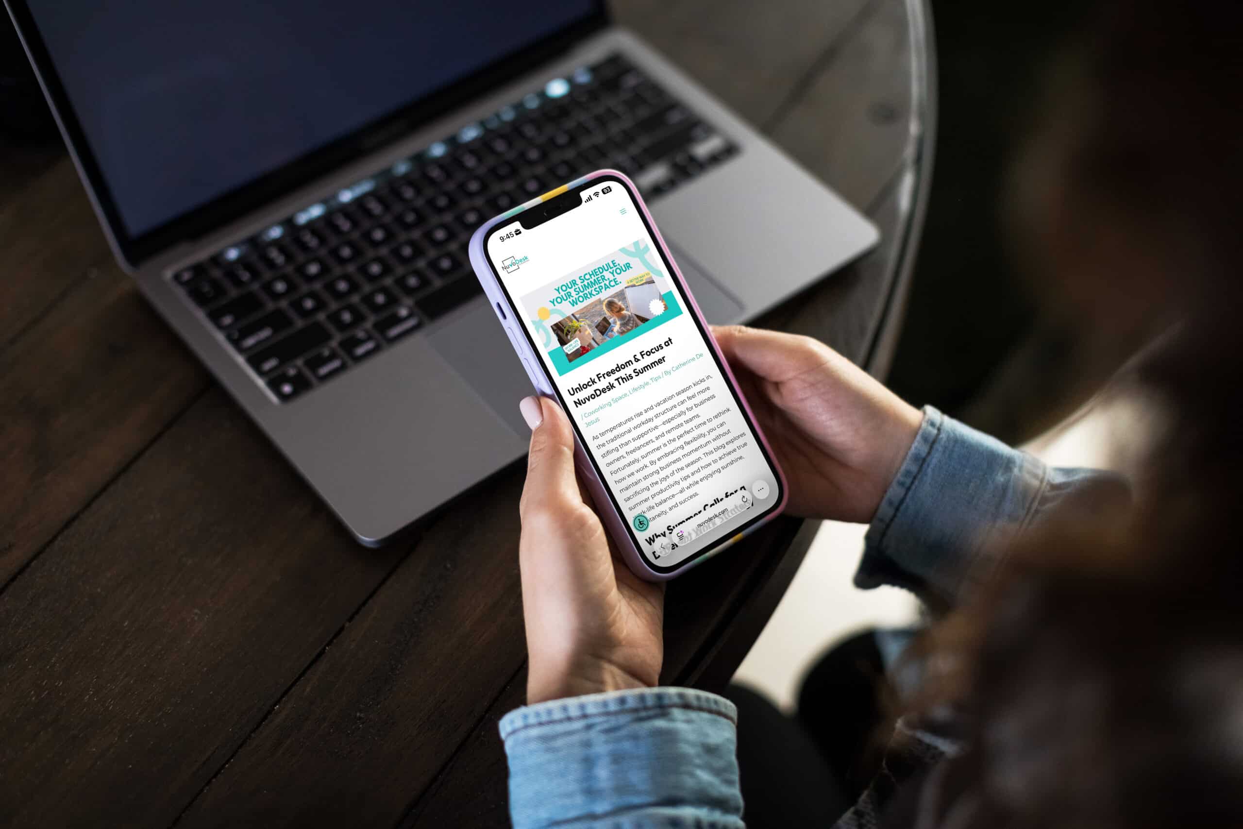 Mobile-friendly display highlighting AI-powered SEO services in action. » Advent Trinity Marketing Agency Person holding iPhone showing coworking website over laptop